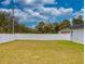 Fenced backyard with grass and trees under a cloudy sky at 15720 Sw 19Th Ter, Ocala, FL 34473