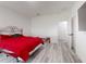 Bedroom featuring red bedding, gray wood-look floors, and white walls at 15720 Sw 19Th Ter, Ocala, FL 34473