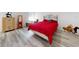 Bedroom with a red comforter, decorative headboard, and gray wood-look floors at 15720 Sw 19Th Ter, Ocala, FL 34473