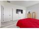 Bright bedroom with a red comforter, wood-look flooring, and white walls at 15720 Sw 19Th Ter, Ocala, FL 34473