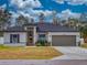 Charming single-story home with a dark gray roof, light gray siding, and a two-car garage at 15720 Sw 19Th Ter, Ocala, FL 34473