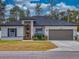 Charming single-story home with a yellow door, attached garage, and landscaped front yard at 15720 Sw 19Th Ter, Ocala, FL 34473