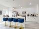 Stylish kitchen with white cabinets, an island with blue velvet bar stools, and modern appliances at 15720 Sw 19Th Ter, Ocala, FL 34473
