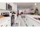 Open kitchen with white cabinets, stainless steel appliances, and an island with bar seating at 15720 Sw 19Th Ter, Ocala, FL 34473