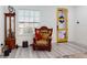 Cozy corner of the living room with an ornate armchair, window with blinds, and view of the front door at 15720 Sw 19Th Ter, Ocala, FL 34473
