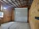 Interior of garage with roll-up door, wooden walls, and concrete floor at 444 Ne 63Rd St, Ocala, FL 34479