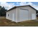 Exterior of a garage with a roll-up door, side door, and white trim at 444 Ne 63Rd St, Ocala, FL 34479