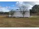 Exterior view of an outbuilding with a metal roof and wooden siding at 444 Ne 63Rd St, Ocala, FL 34479