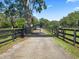 Black wrought iron gate entrance with a long driveway at 6657 W Highway 326, Ocala, FL 34482