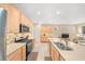 Bright open kitchen with stainless steel appliances, double sink, breakfast bar, and ample wood cabinetry at 7932 Sw 89Th Cir, Ocala, FL 34481