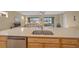 Kitchen island with double sink, dishwasher, and view into the living room at 7932 Sw 89Th Cir, Ocala, FL 34481