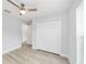Bedroom with wood-look flooring, ceiling fan, and large closet at 13573 Sw 115 Pl, Dunnellon, FL 34432