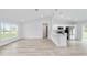 Open-concept living space with wood-look floors, high ceilings, and a modern kitchen at 13573 Sw 115 Pl, Dunnellon, FL 34432