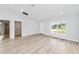 Open living area with wood-look flooring, high ceilings, and a view of a laundry room at 13573 Sw 115 Pl, Dunnellon, FL 34432