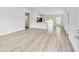 Open-concept living area with wood-look flooring, high ceilings, and adjacent kitchen and dining space at 13573 Sw 115 Pl, Dunnellon, FL 34432