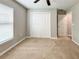 Empty bedroom with carpeted floors, a ceiling fan, white closet doors, and a window at 17752 Sw 36Th Loop, Dunnellon, FL 34432