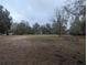 Pasture land with a metal feeding trough, trees, and some grass at 18695 Ne 5Th Terrace Rd, Citra, FL 32113