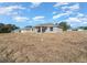 Backyard of a home with a covered patio and a large grassy area at 281 Locust Pass, Ocala, FL 34472