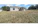 View of a house's backyard with a covered patio and grassy yard at 281 Locust Pass, Ocala, FL 34472