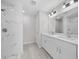 Modern bathroom with double vanity, marble tile shower, and wood-look flooring at 281 Locust Pass, Ocala, FL 34472