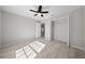 Bright bedroom with wood-look flooring, ceiling fan, and open closet at 281 Locust Pass, Ocala, FL 34472