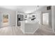 Kitchen with island, stainless steel appliances, white cabinetry, and wood-look flooring at 281 Locust Pass, Ocala, FL 34472