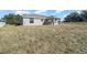 View of the backyard with a covered patio and dry grass at 283 Locust Pass, Ocala, FL 34472