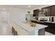 Modern kitchen featuring dark wood cabinets, stainless steel appliances, and an island with seating at 320 Hickory Course Trl, Ocala, FL 34472