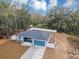 High angle aerial view of a gray home with a teal garage and large fenced yard at 4250 Se 131St Ln, Belleview, FL 34420