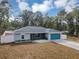 Front exterior view of a single-story home with teal double garage doors at 4250 Se 131St Ln, Belleview, FL 34420