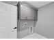 Laundry room with gray cabinets and white tile floor at 4250 Se 131St Ln, Belleview, FL 34420