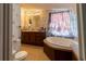 Main bathroom with double vanity, garden tub, toilet, and patterned curtains at 8111 County Road 109, Lady Lake, FL 32159