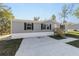 Gray manufactured home with a concrete driveway and grassy yard at 18478 Se 58Th Pl, Ocklawaha, FL 32179