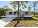 Gray manufactured home with a concrete driveway and landscaped lawn at 18478 Se 58Th Pl, Ocklawaha, FL 32179