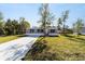 Gray manufactured home with a concrete driveway and grassy yard at 18478 Se 58Th Pl, Ocklawaha, FL 32179