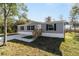 Gray manufactured home with wooden steps and a concrete driveway at 18478 Se 58Th Pl, Ocklawaha, FL 32179