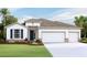 Charming single-story home with a three-car garage and landscaped front yard at 3092 Canopy Oak Blvd, Wildwood, FL 34785