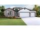Inviting single-story home with a three-car garage and stone accents at 3095 Canopy Oak Blvd, Wildwood, FL 34785