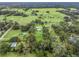 Aerial view showing a house nestled amongst lush greenery and neighboring properties at 3505 Ne 97Th Street Rd, Anthony, FL 32617