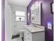 Updated bathroom features a white vanity with granite top, tiled shower, and purple walls at 3505 Ne 97Th Street Rd, Anthony, FL 32617