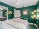 Charming guest bedroom with green walls, brass bed frame, and ceiling fan at 3505 Ne 97Th Street Rd, Anthony, FL 32617