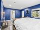 Blue walls and a king-size bed in this bright and airy bedroom with ensuite bathroom access at 3505 Ne 97Th Street Rd, Anthony, FL 32617