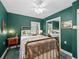 Guest bedroom with green walls, brass bed frame, and ceiling fan at 3505 Ne 97Th Street Rd, Anthony, FL 32617