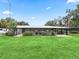 Ranch-style home with a covered porch and manicured lawn at 3505 Ne 97Th Street Rd, Anthony, FL 32617