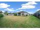 Backyard with a covered patio, lush green lawn, and a black metal fence at 3810 Se 4Th Ter, Ocala, FL 34480