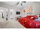 bedroom with red bedding, ceiling fan, and wall-mounted TV at 3810 Se 4Th Ter, Ocala, FL 34480