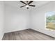 Bright bedroom with ceiling fan, wood-look floors, and large window at 39926 Parkinsonia St, Lady Lake, FL 32159
