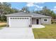 New construction home, gray exterior, white garage door, black front door at 39926 Parkinsonia St, Lady Lake, FL 32159