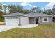 Newly built gray house with white garage door and black front door at 39926 Parkinsonia St, Lady Lake, FL 32159