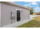 Exterior storage area with black door and electrical panel at 39926 Parkinsonia St, Lady Lake, FL 32159